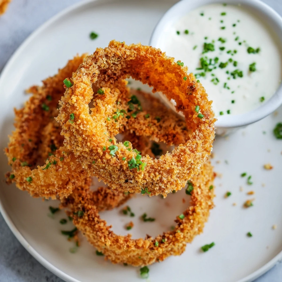 Freshly baked Crispy Baked Onion Rings with Ranch Dressing showcasing crunchy panko coating and a side of creamy ranch.