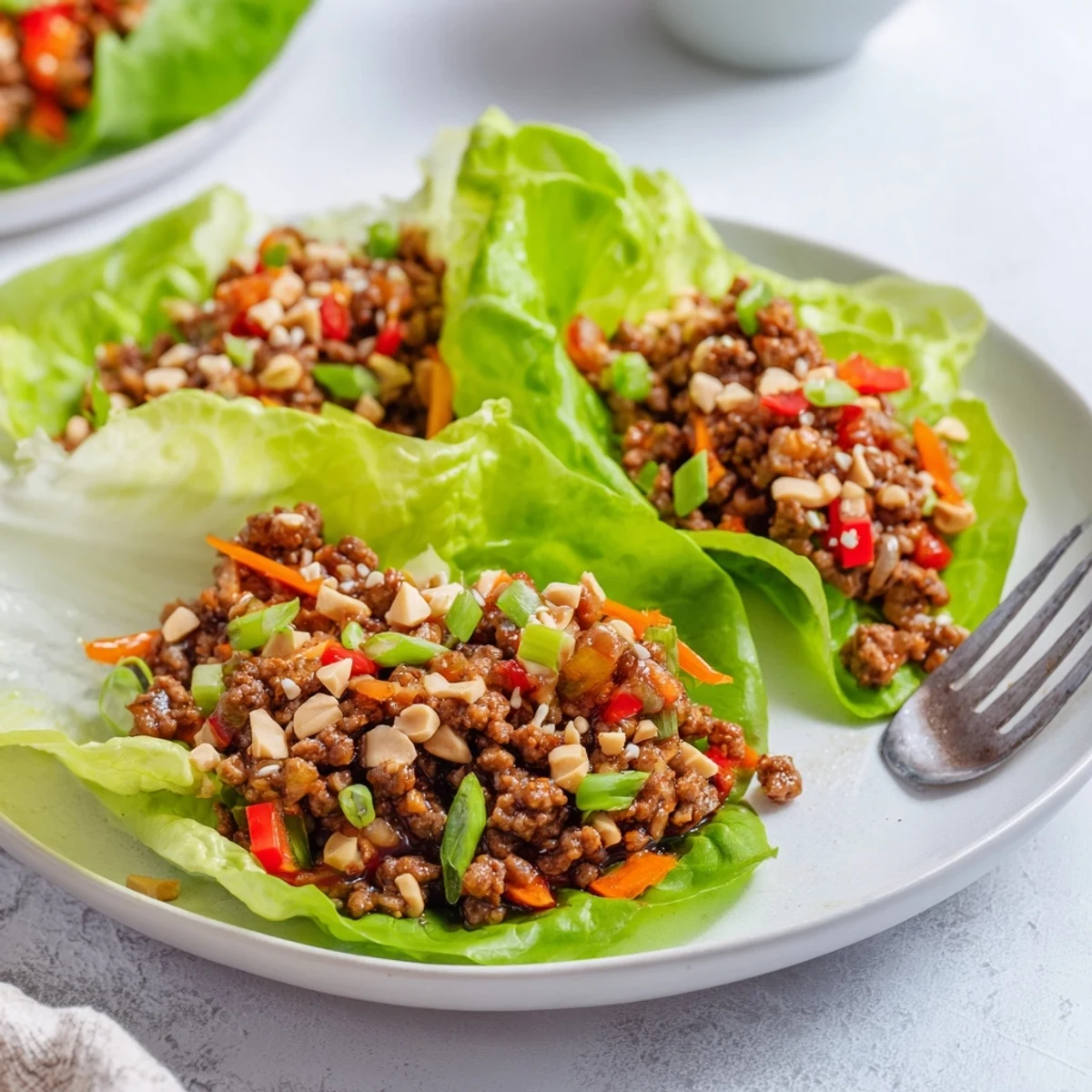 Savory hoisin beef filling piled onto fresh lettuce leaves, ready to be enjoyed as a light, dairy-free appetizer or main course.