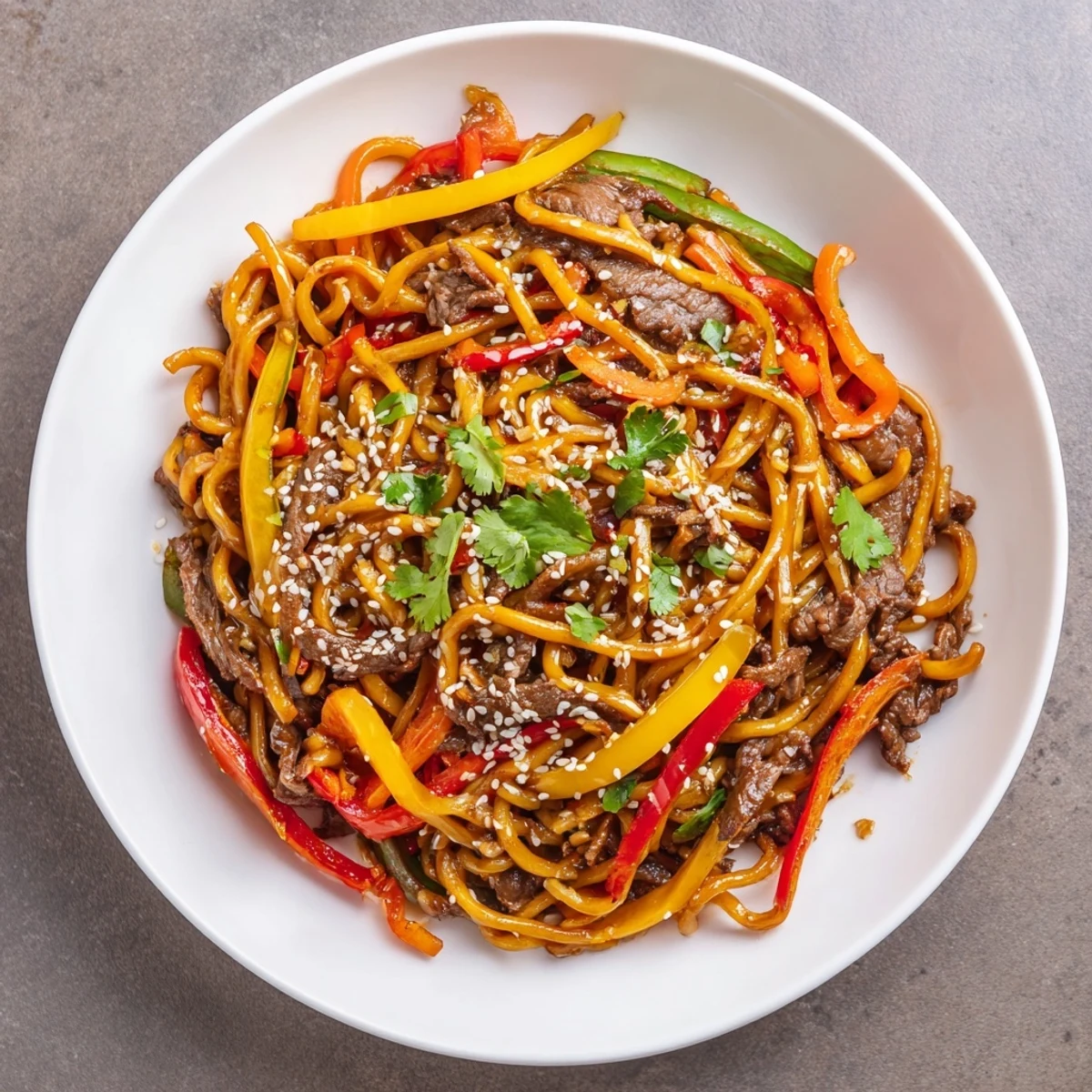 Sizzling strips of beef, crisp bell peppers, and chewy noodles are tossed in a spicy, savory sauce in this Asian-inspired Spicy Beef Stir Fry with Noodles.  