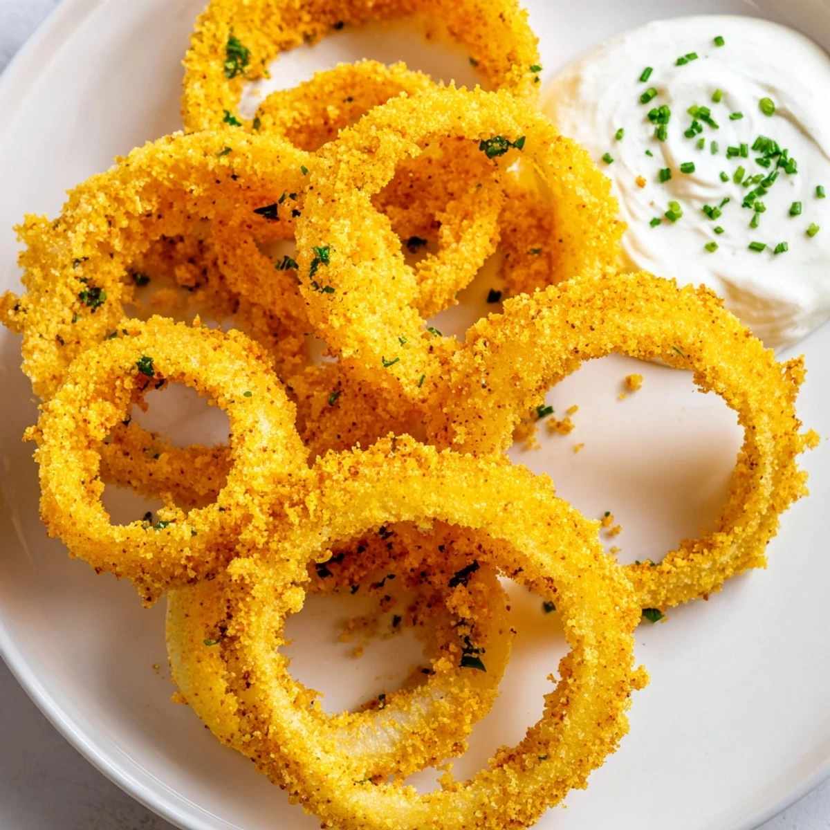 Freshly fried golden-brown Touchdown Crispy Onion Rings with ranch dip, served hot on a platter for a crowd-pleasing appetizer.  