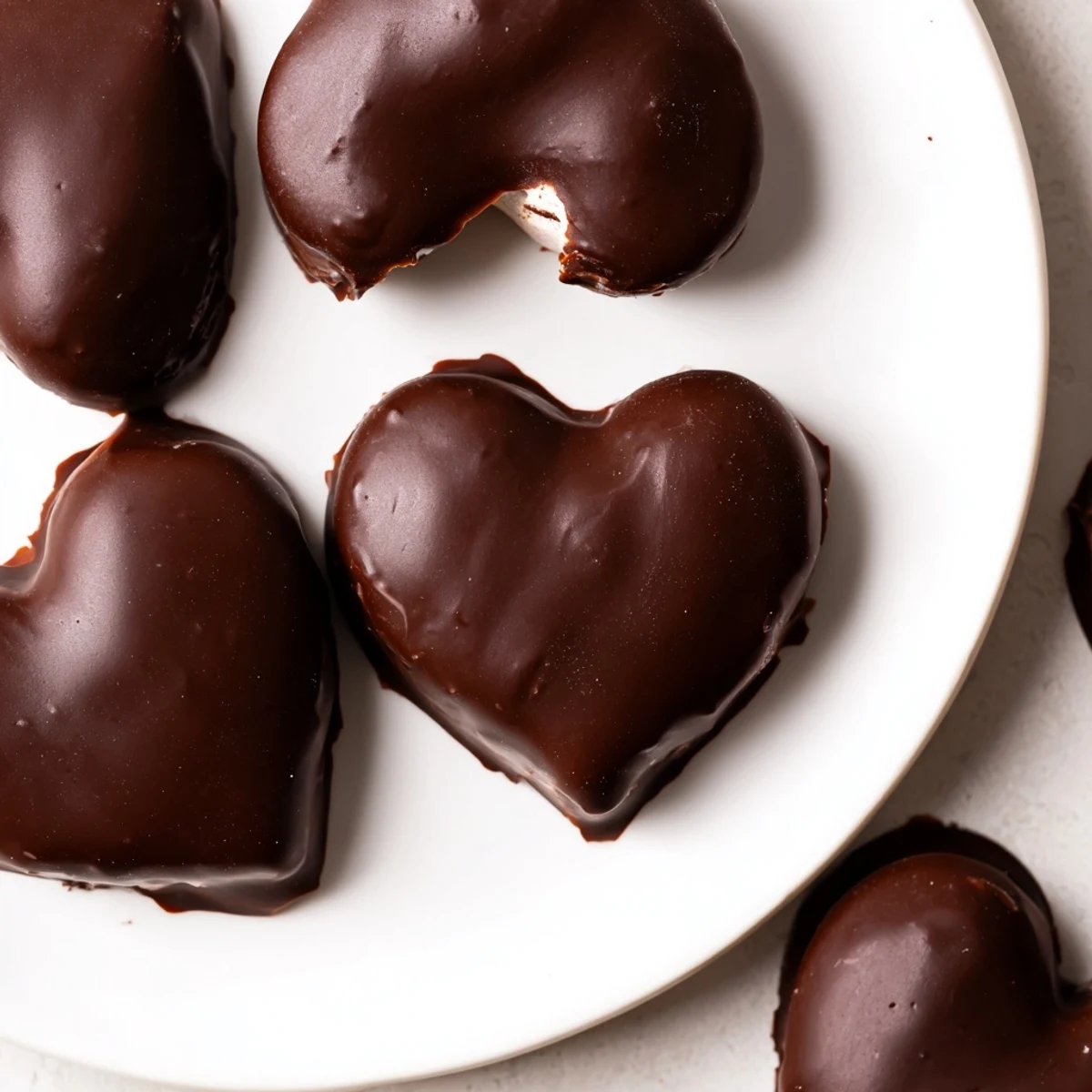 A close-up of a chocolate peanut butter heart shows the firm filling and smooth coating, ideal for Valentine's Day gifting.  