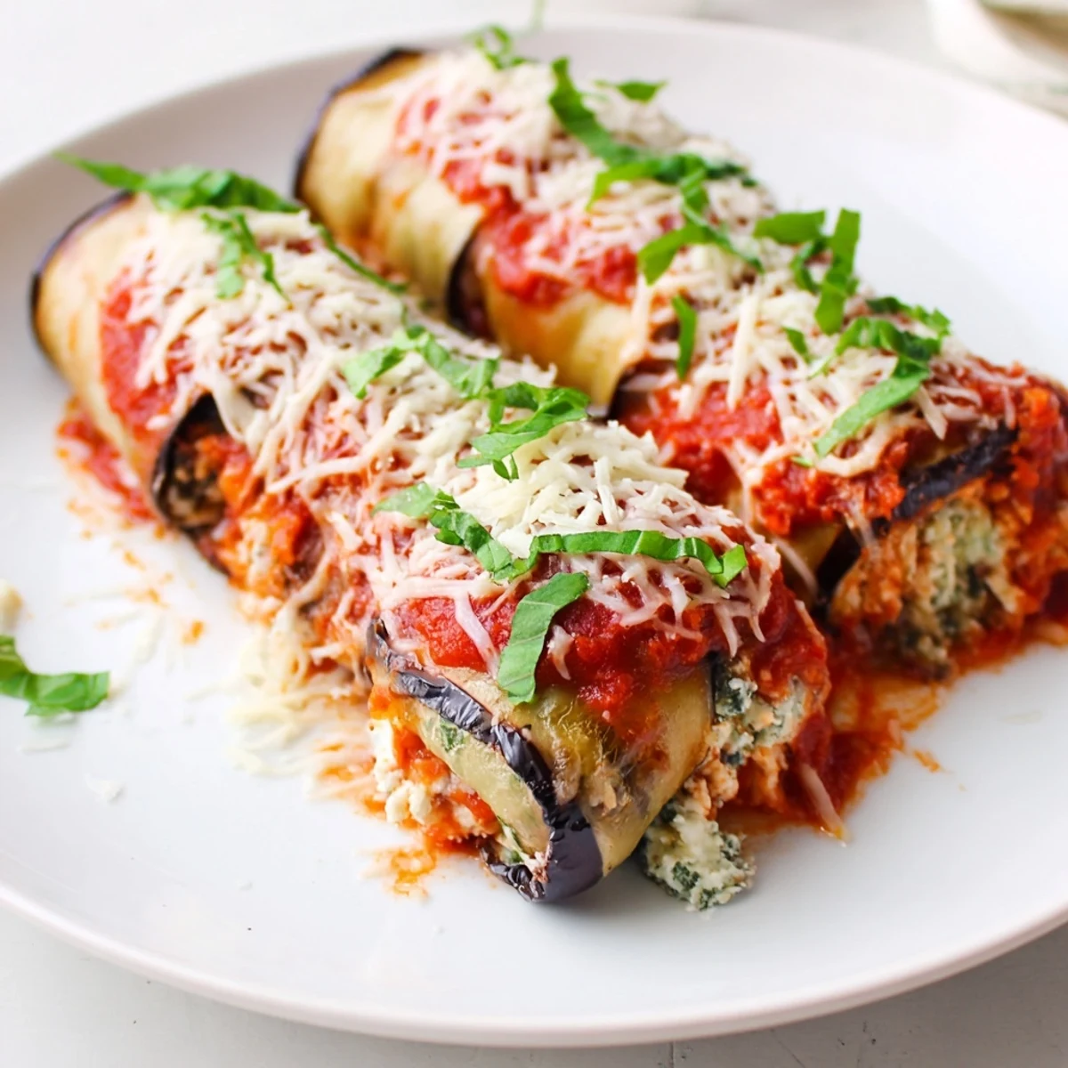 Golden roasted eggplant slices are rolled with creamy ricotta cheese, baked in marinara sauce and topped with melted mozzarella for a classic Italian vegetarian dinner.