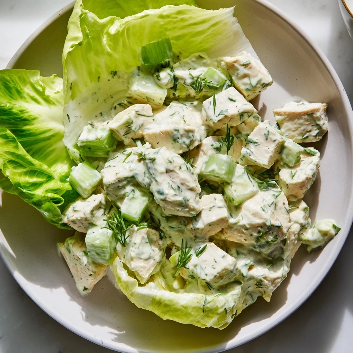 Plump butter lettuce leaves cradle a creamy, herb-flecked Green Goddess Chicken Salad, garnished with chives and ready for a refreshing, low-carb dinner.