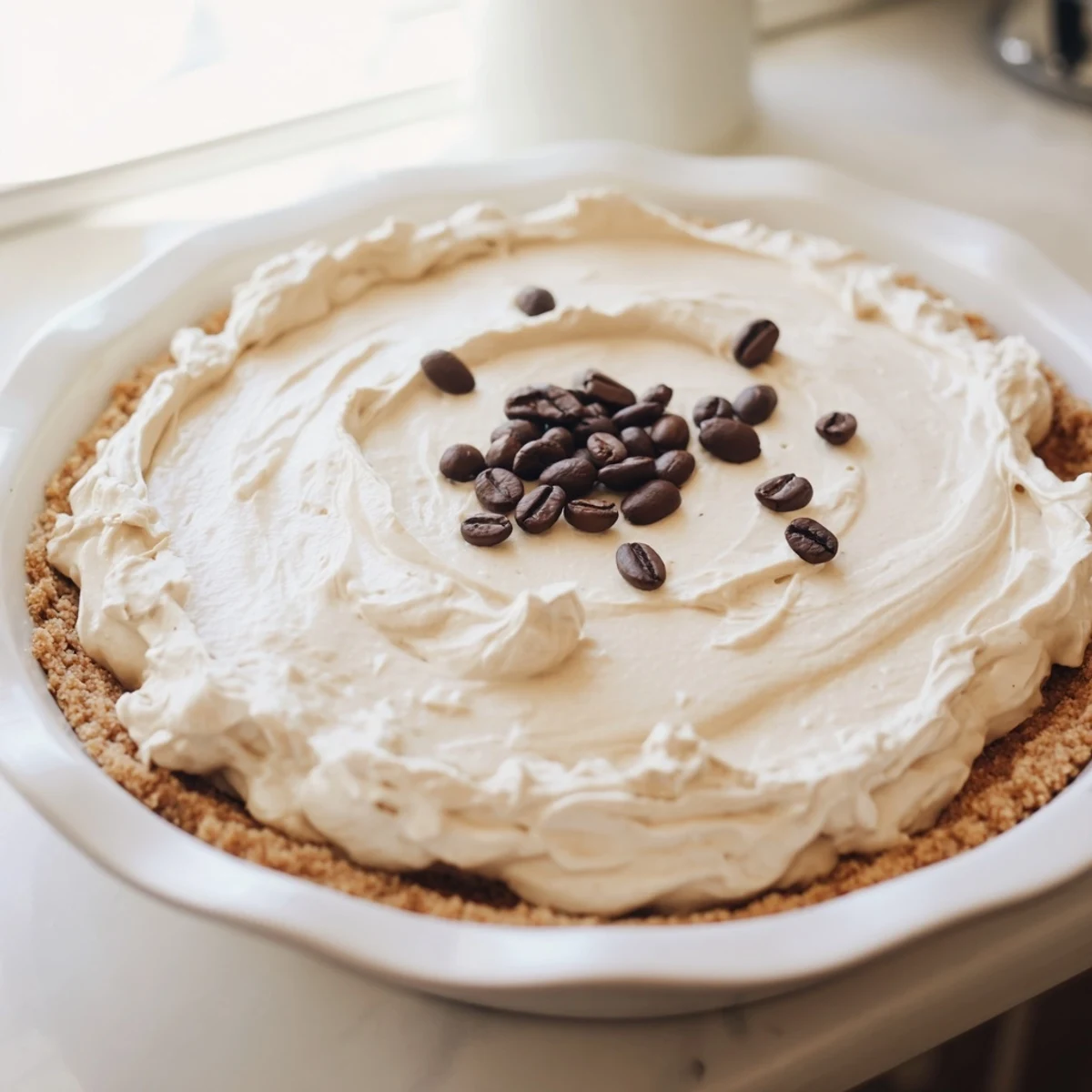 The Keto Cold Brew Coffee Pie features a smooth, coffee-infused dessert with an optional garnish of cocoa powder and coffee beans.