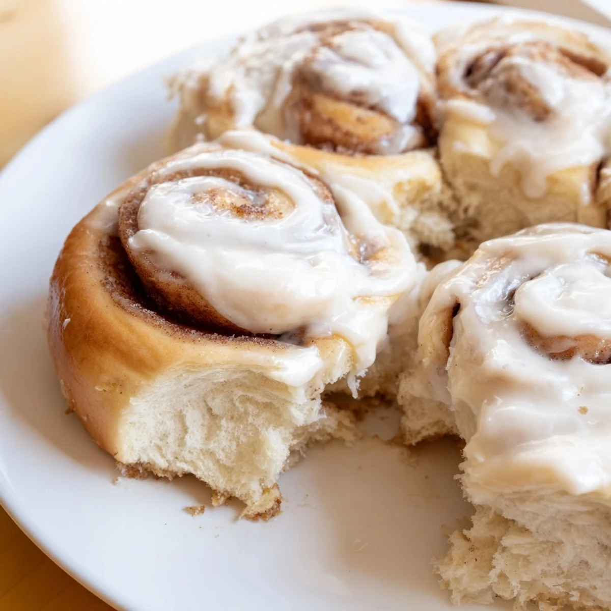 Golden-brown Keto Cinnamon Buns fresh from the oven, with creamy white icing drizzled over the soft, fluffy tops.