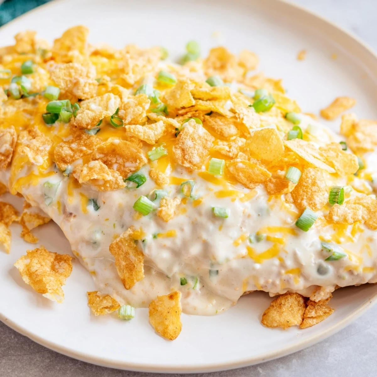 Bubbling Sour Cream and Onion Chicken from the oven, presented on a plate with steamed vegetables and mashed potatoes.