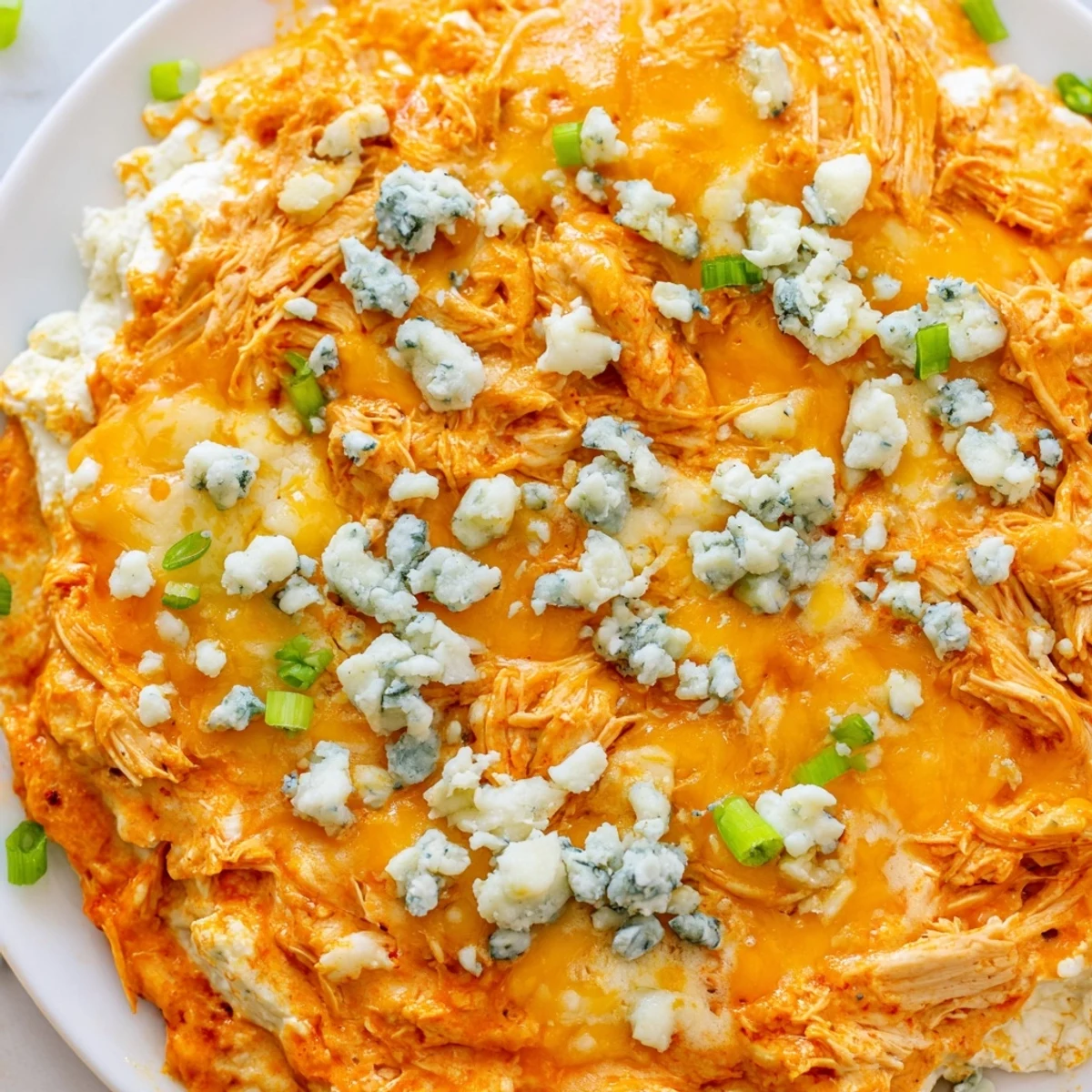 Keto Buffalo Chicken Dip ready to serve, with a golden, bubbly cheese crust and a side of crisp celery for dipping.
