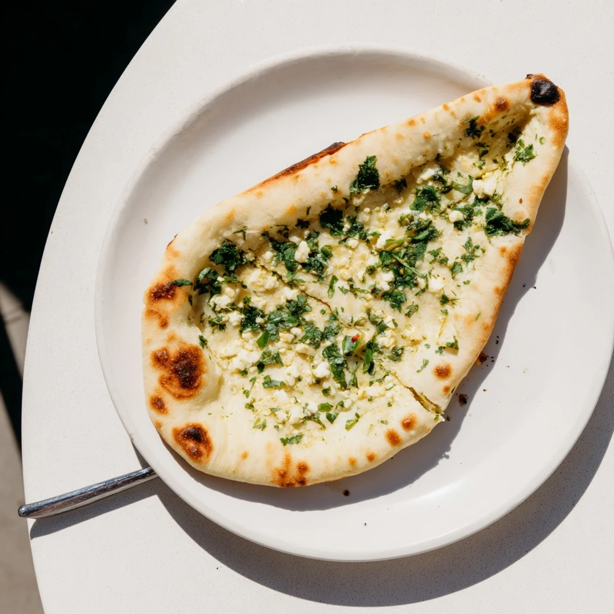 Golden-brown Cottage Cheese Garlic Naan fresh off the skillet, brushed with melted butter and flecked with fresh cilantro.