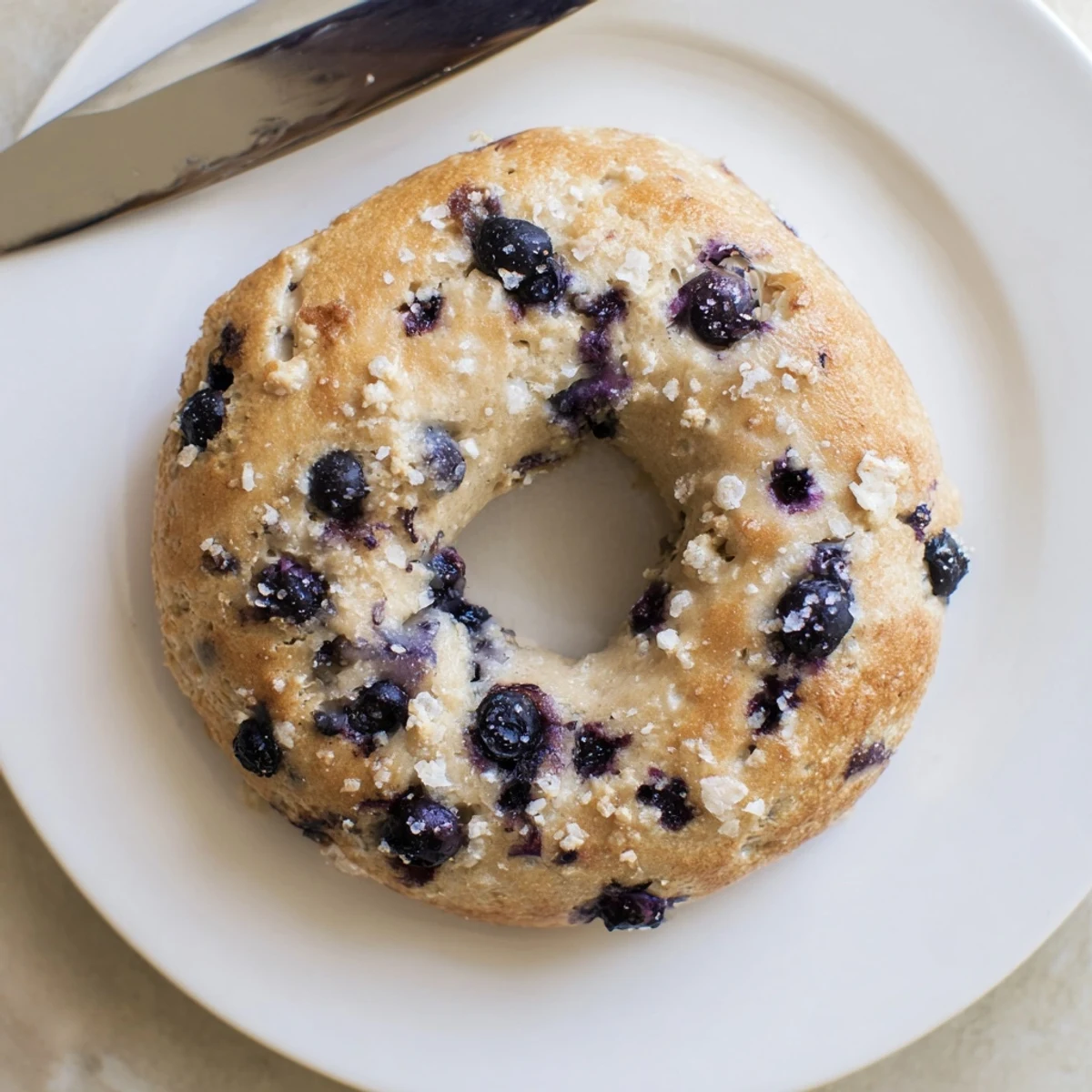 A close-up of gluten-free blueberry bagels, perfect for breakfast with cream cheese spread.