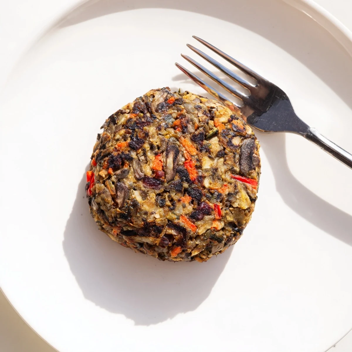 Mushroom veggie burgers served on a toasted bun with fresh lettuce, tomato, and pickles.  