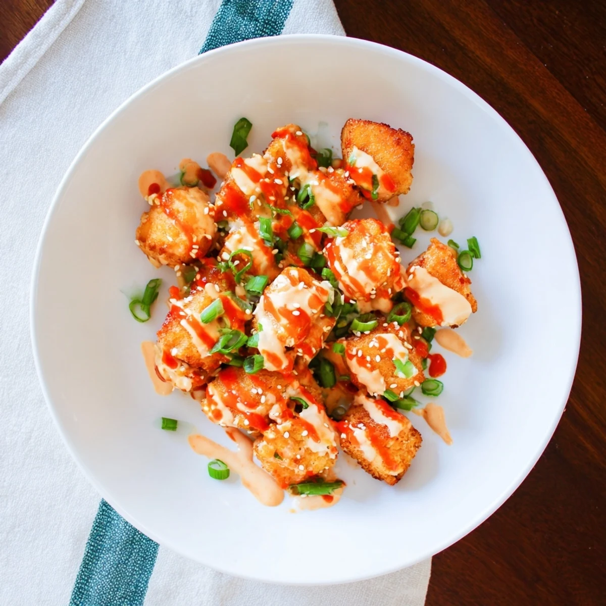 Crispy golden Bang Bang Salmon Bites with creamy spicy sauce and fresh chives garnish.
