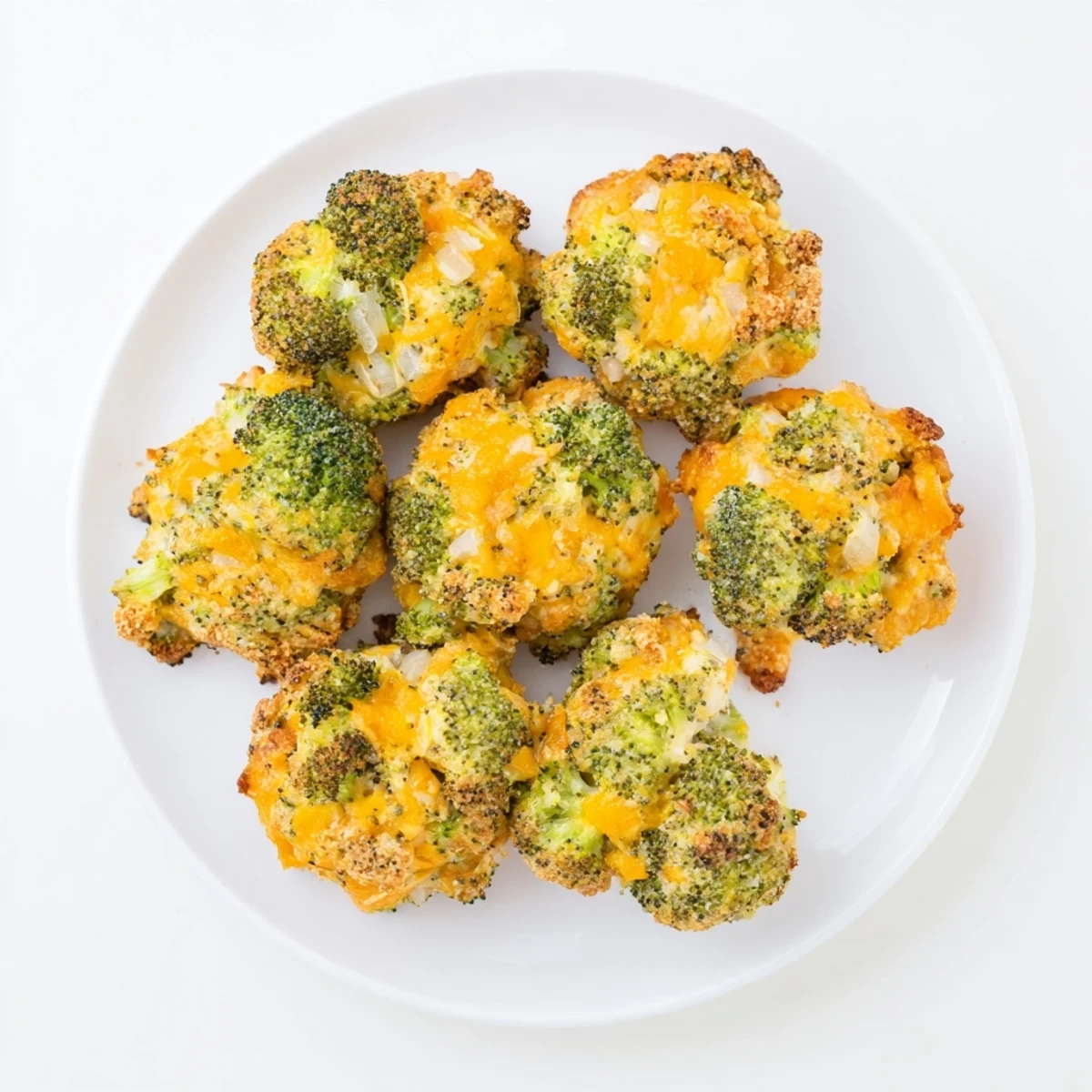 Close up of gooey baked broccoli and cheese balls with dipping sauce