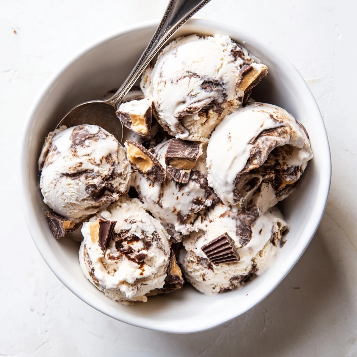 Bowl of Homemade Moose Tracks Ice Cream showing marbled fudge swirl and chocolate candy mix-ins