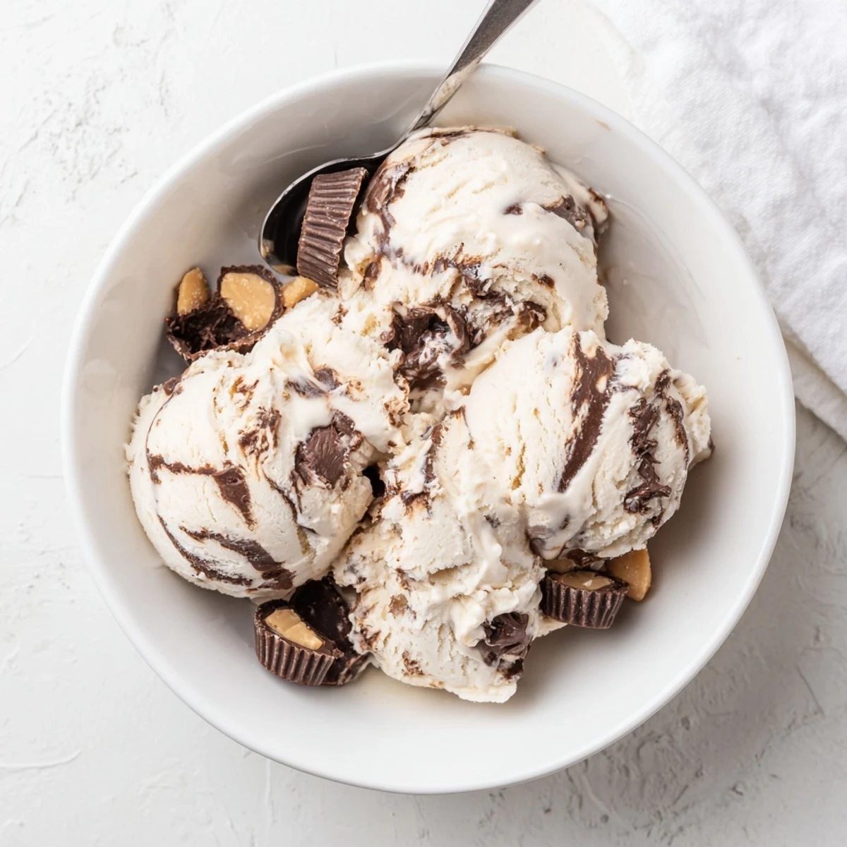 Scoop of Homemade Moose Tracks Ice Cream topped with fudge sauce and peanut butter cup pieces