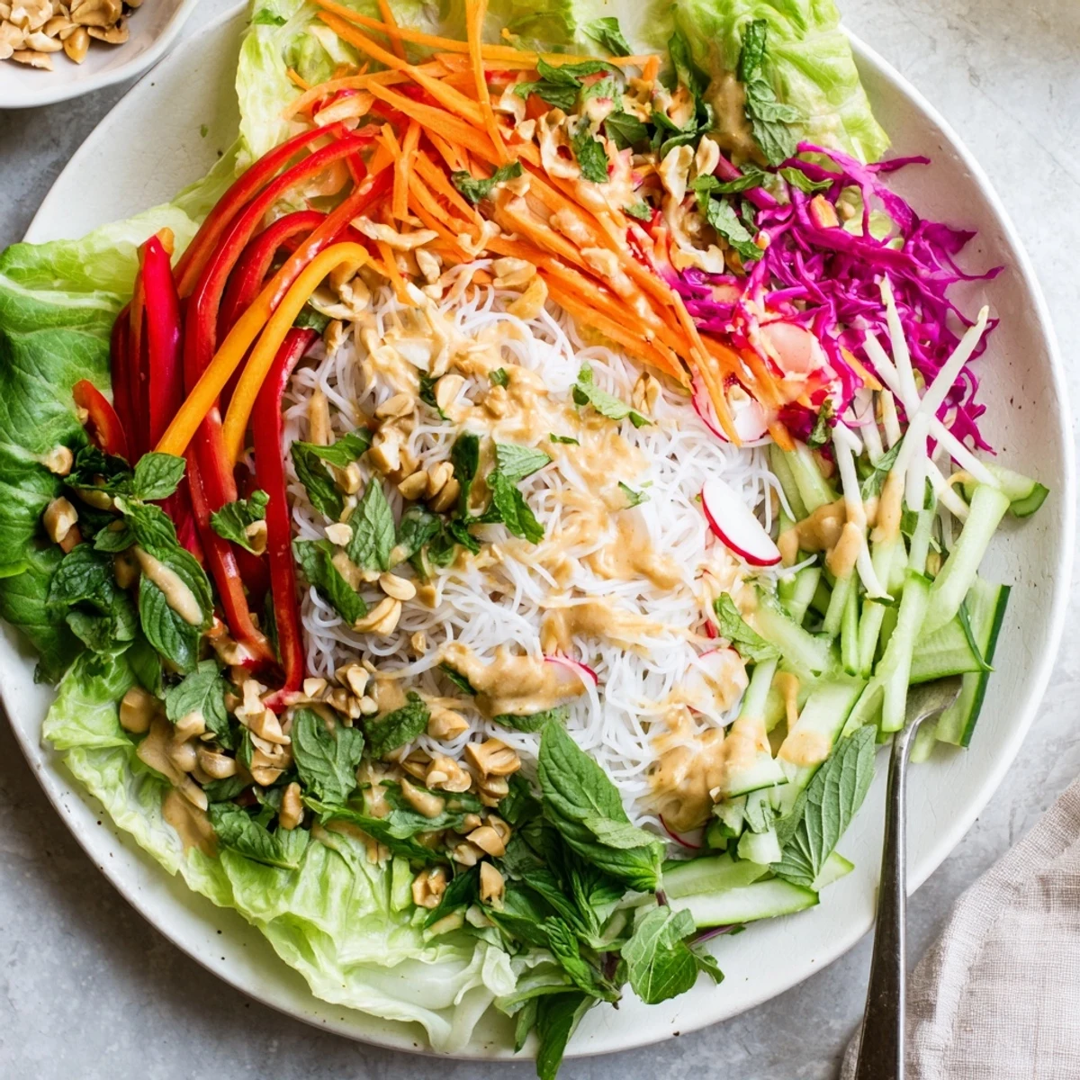Vibrant Vietnamese-inspired spring roll salad with peanut dressing arranged on crisp lettuce leaves