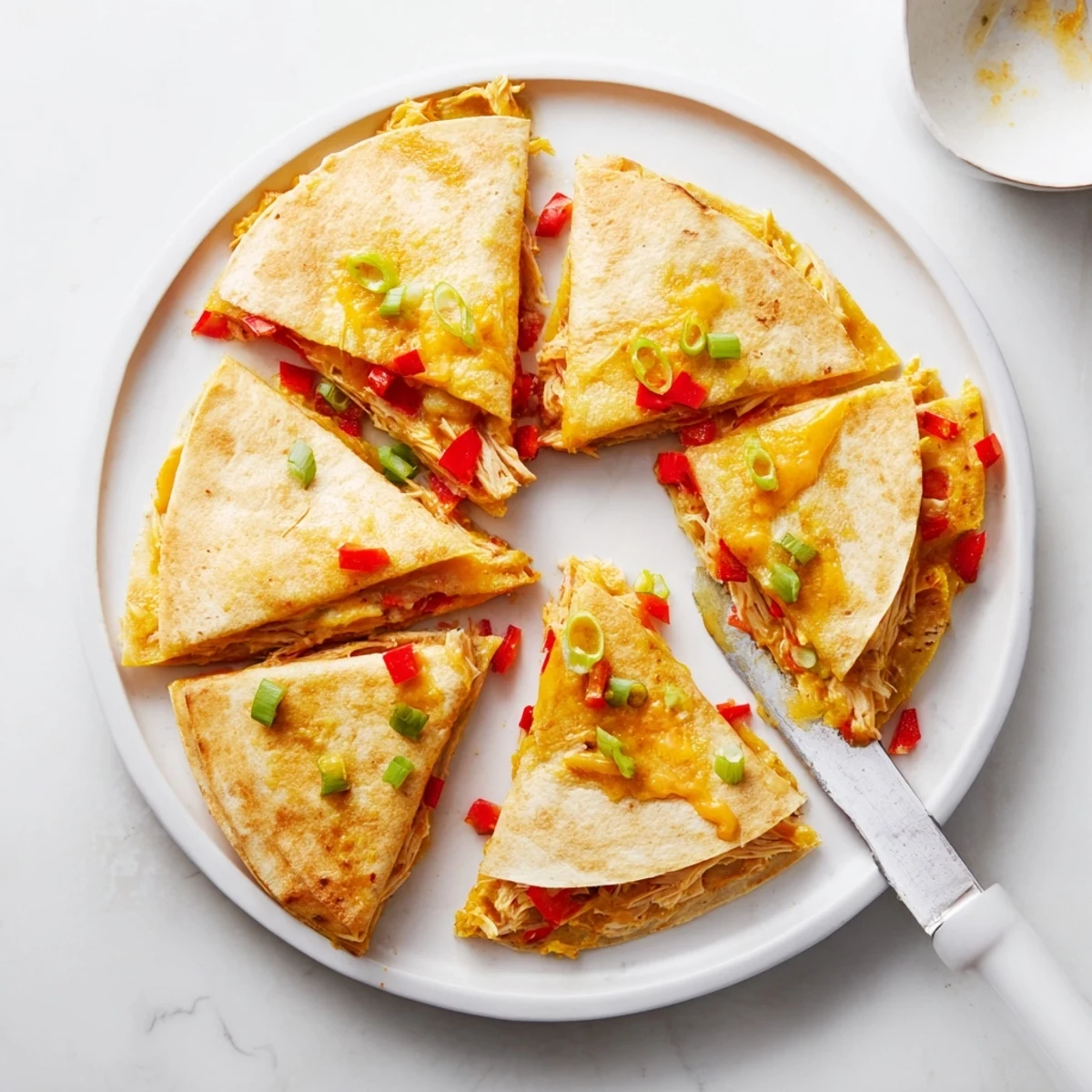 Easy chicken and cheese quesadillas displaying golden tortillas with visible red bell pepper pieces