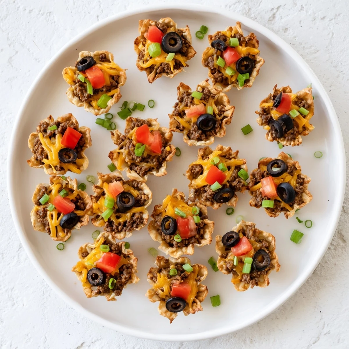 Baked Tex-Mex appetizer bites featuring taco seasoned beef ranch mixture and bubbly cheese garnish