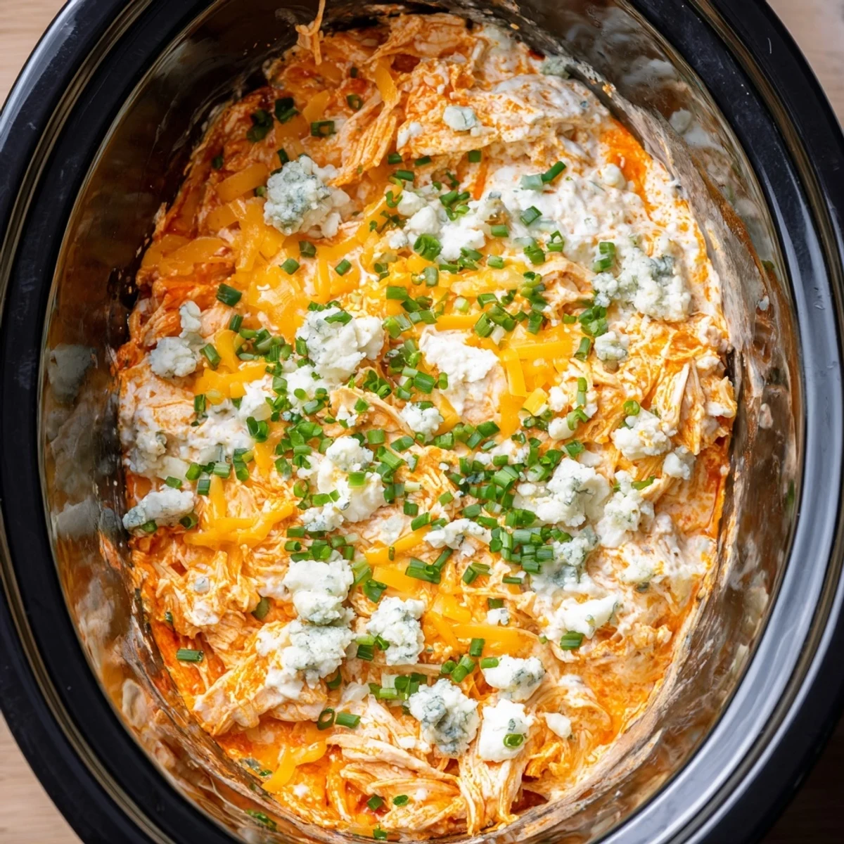 Creamy Crockpot Buffalo Chicken Dip bubbling with melted cheddar and mozzarella cheeses