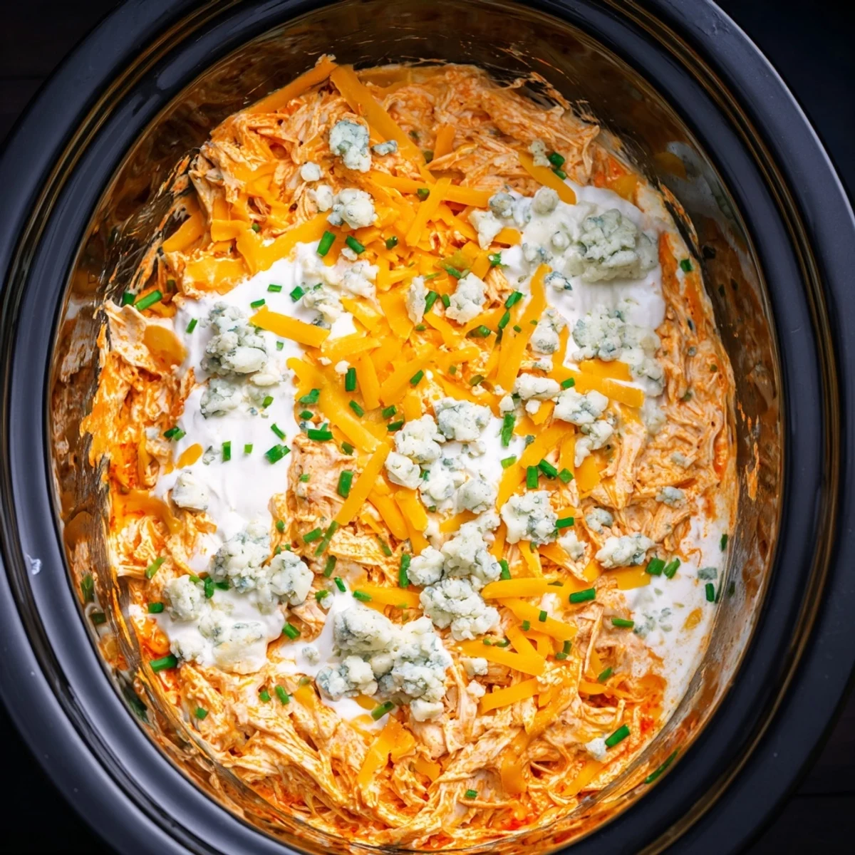 Golden buffalo chicken dip served warm with crunchy tortilla chips and fresh celery sticks