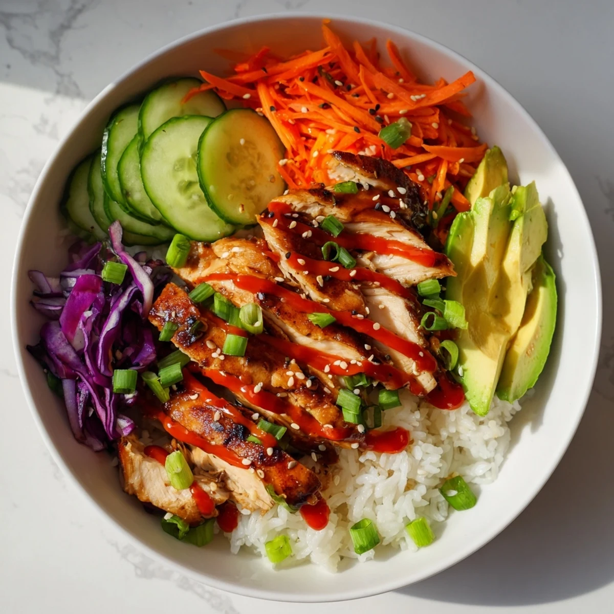 Savory Korean BBQ chicken bowl showcasing charred glazed meat atop jasmine rice with shredded carrots and spicy creamy sauce