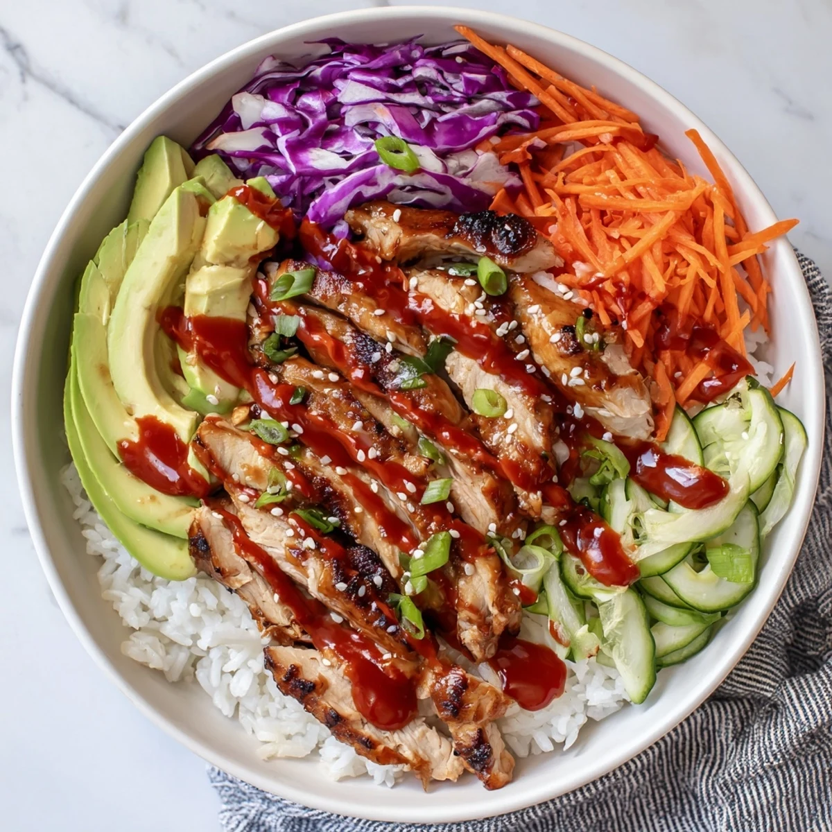 Vibrant Korean BBQ chicken bowl with marinated grilled thighs sliced over rice topped with fresh avocado and crunchy vegetables