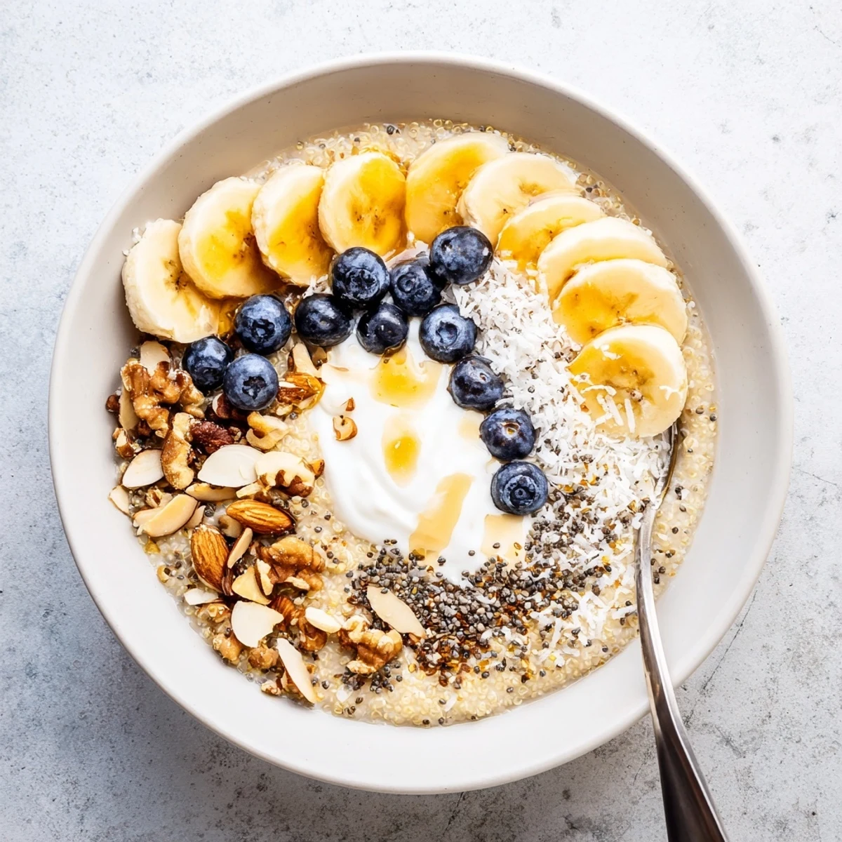 Nourishing blueberry quinoa breakfast bowl featuring Greek yogurt, sweet maple drizzle, and vibrant berries