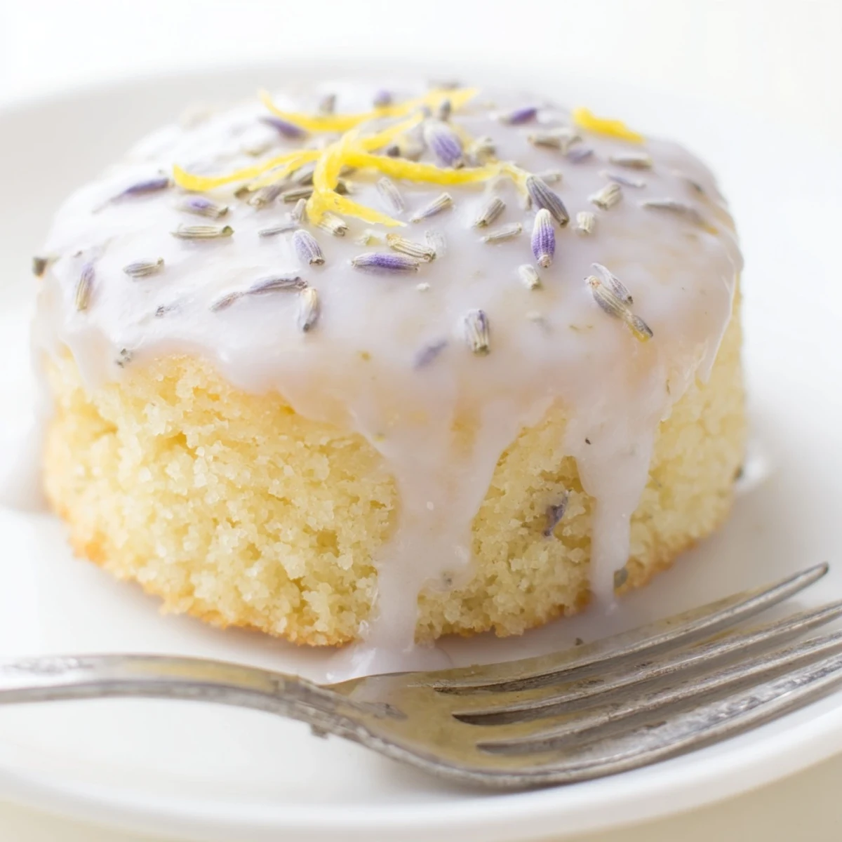Golden mini lemon cakes with lavender glaze dripping over tender crumb tops
