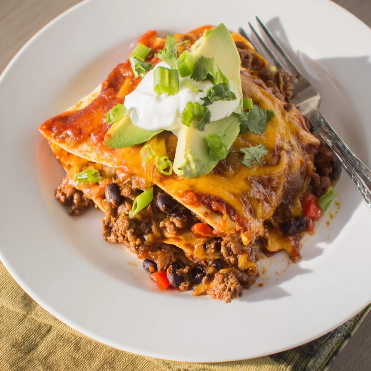 Beef Skillet Enchiladas bubbling with melted cheese, garnished with cilantro and avocado