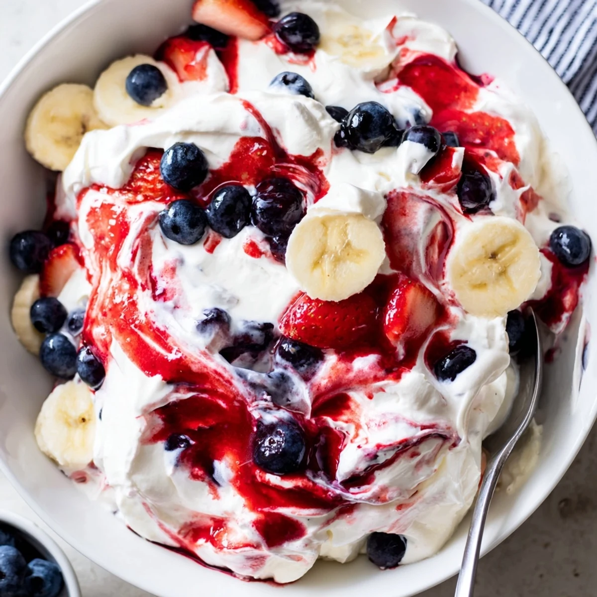 Creamy Red White And Blue Cheesecake Salad with juicy strawberries and blueberries