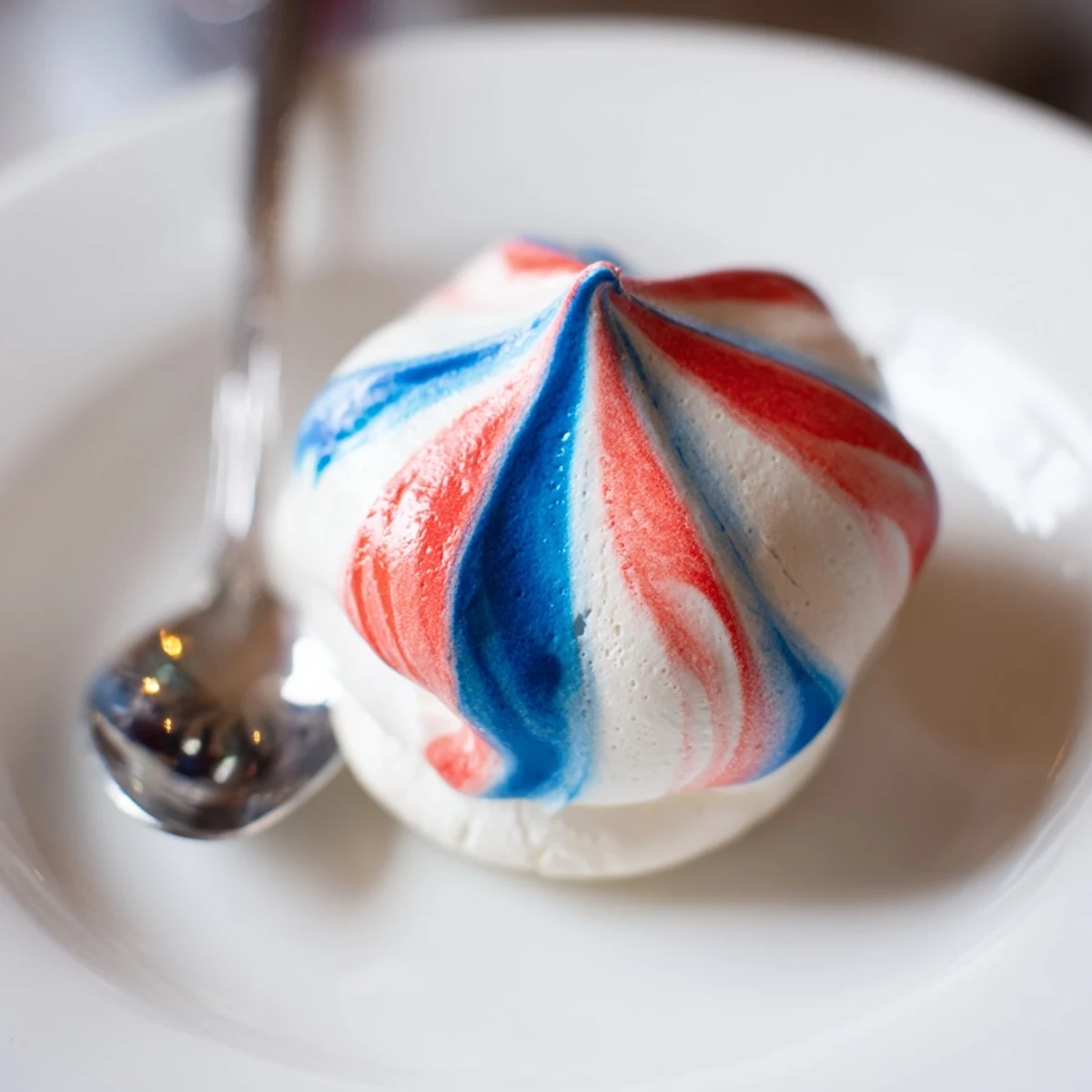 Patriotic Meringue Kisses: crisp red, white, and blue shells on parchment.