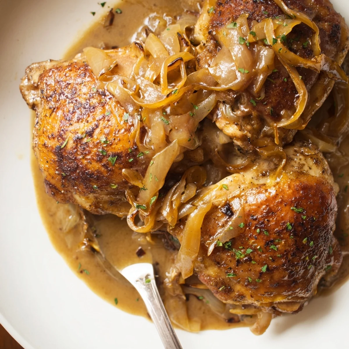 Savory Smothered Chicken Thighs In Rich Gravy Recipe plated over creamy mashed potatoes