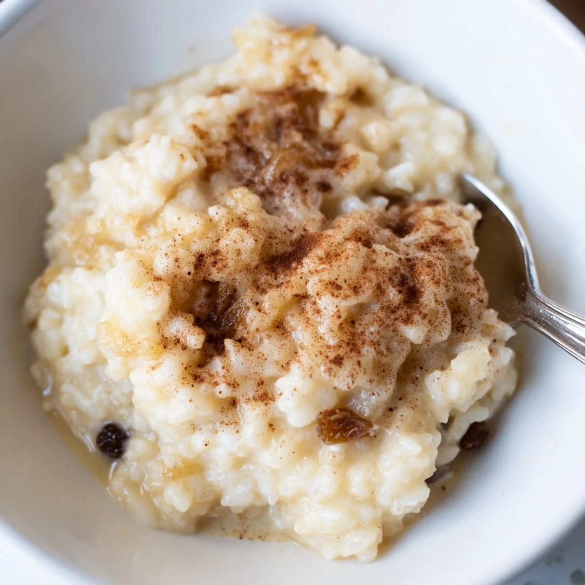 Golden-topped condensed milk baked rice pudding glowing in dish, warm and fragrant