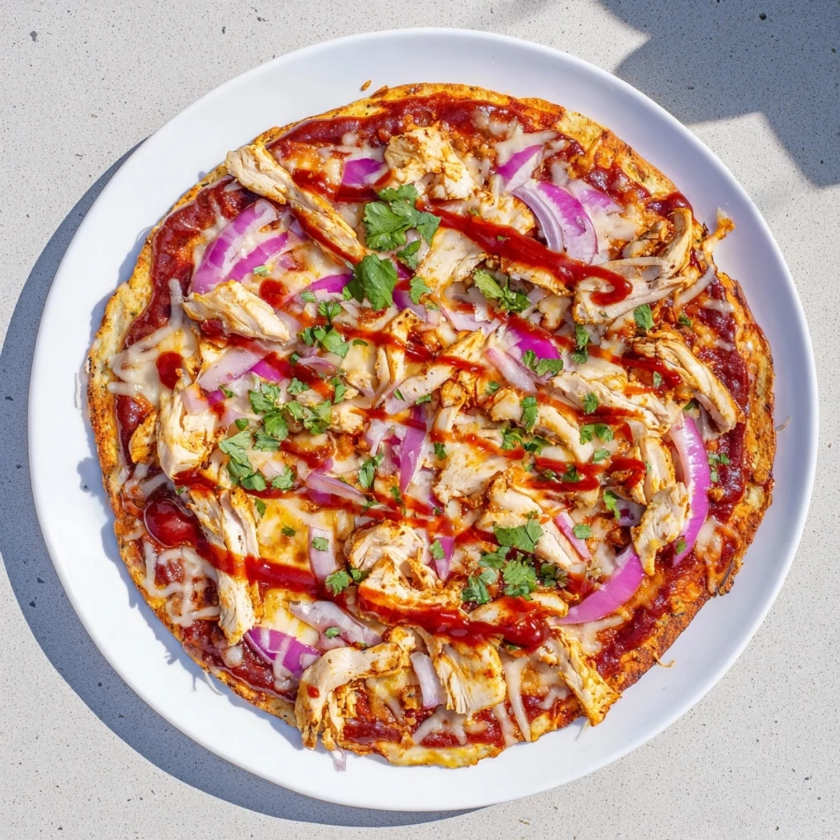 Golden brown grilled BBQ chicken pizza topped with melted mozzarella and red onion slices