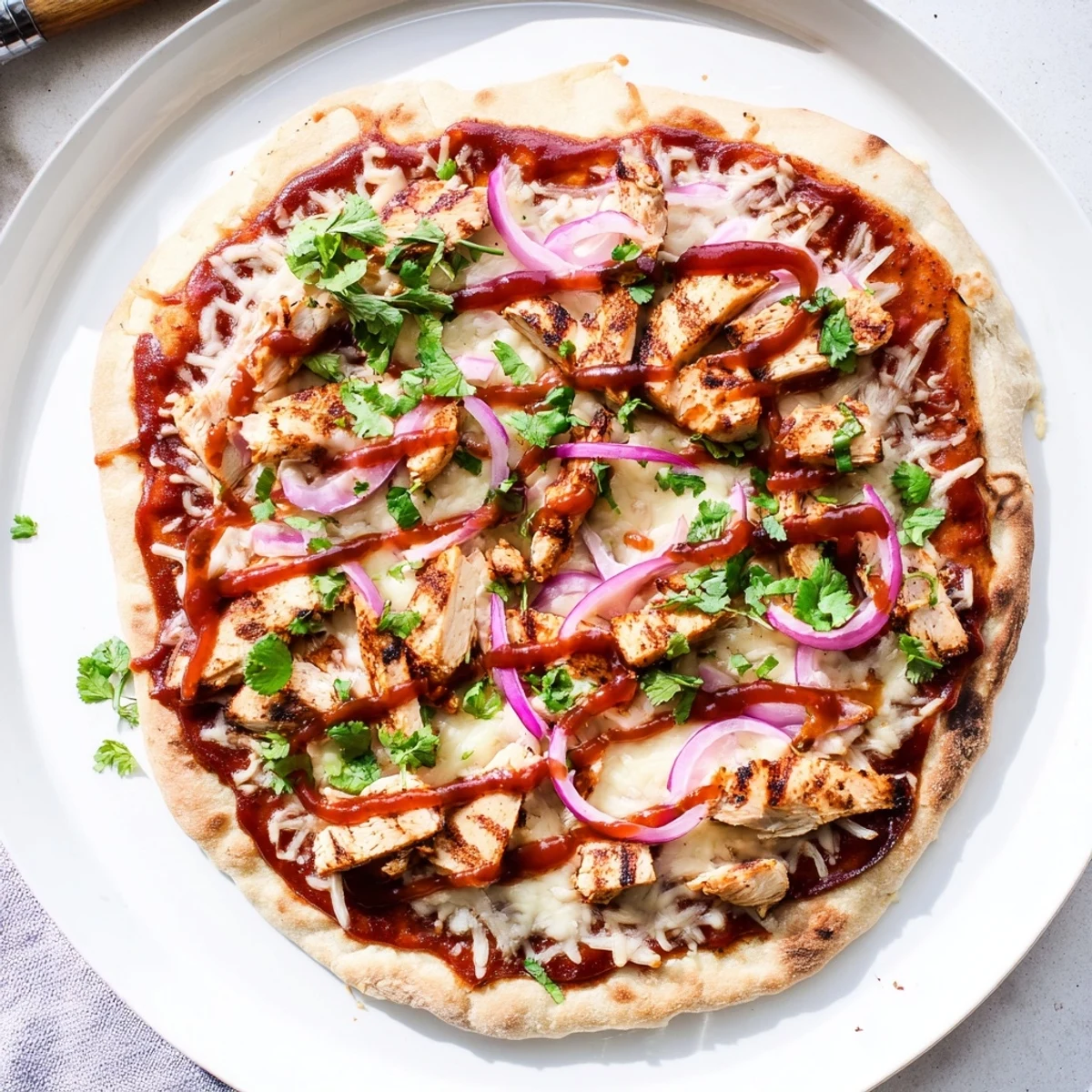 Slice of BBQ chicken pizza featuring grilled chicken breast on a crispy grilled crust