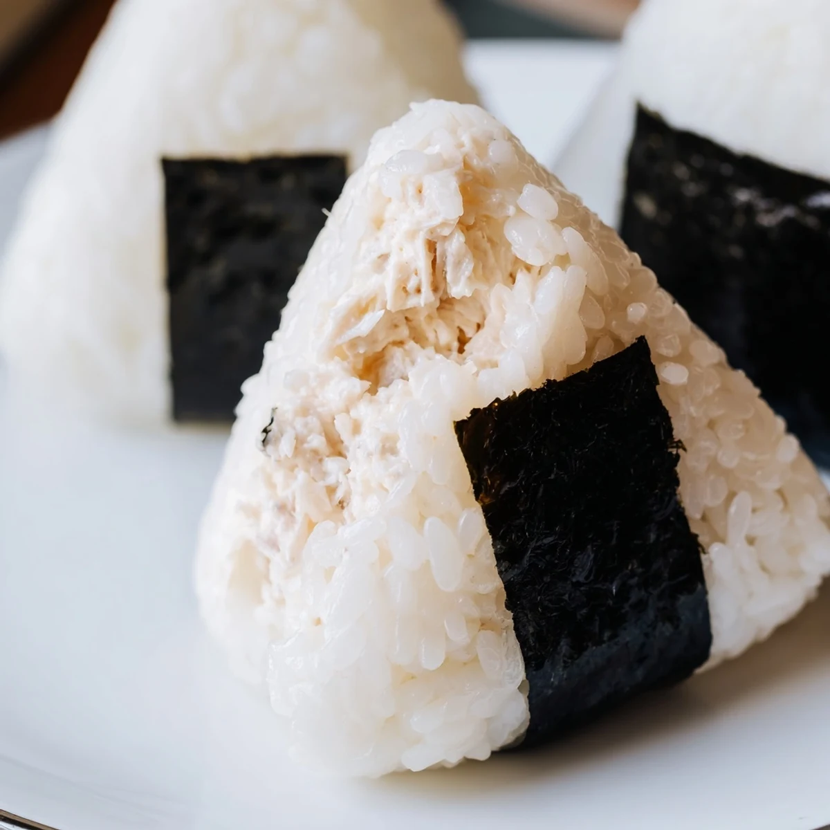 Handheld triangle tuna mayo onigiri wrapped in crispy nori seaweed strips