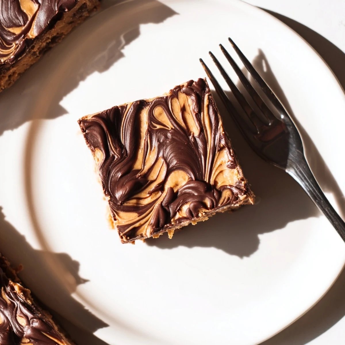 Homemade peanut butter bars showcasing layered chocolate frosting on a rustic wooden cutting board with scattered crumbs