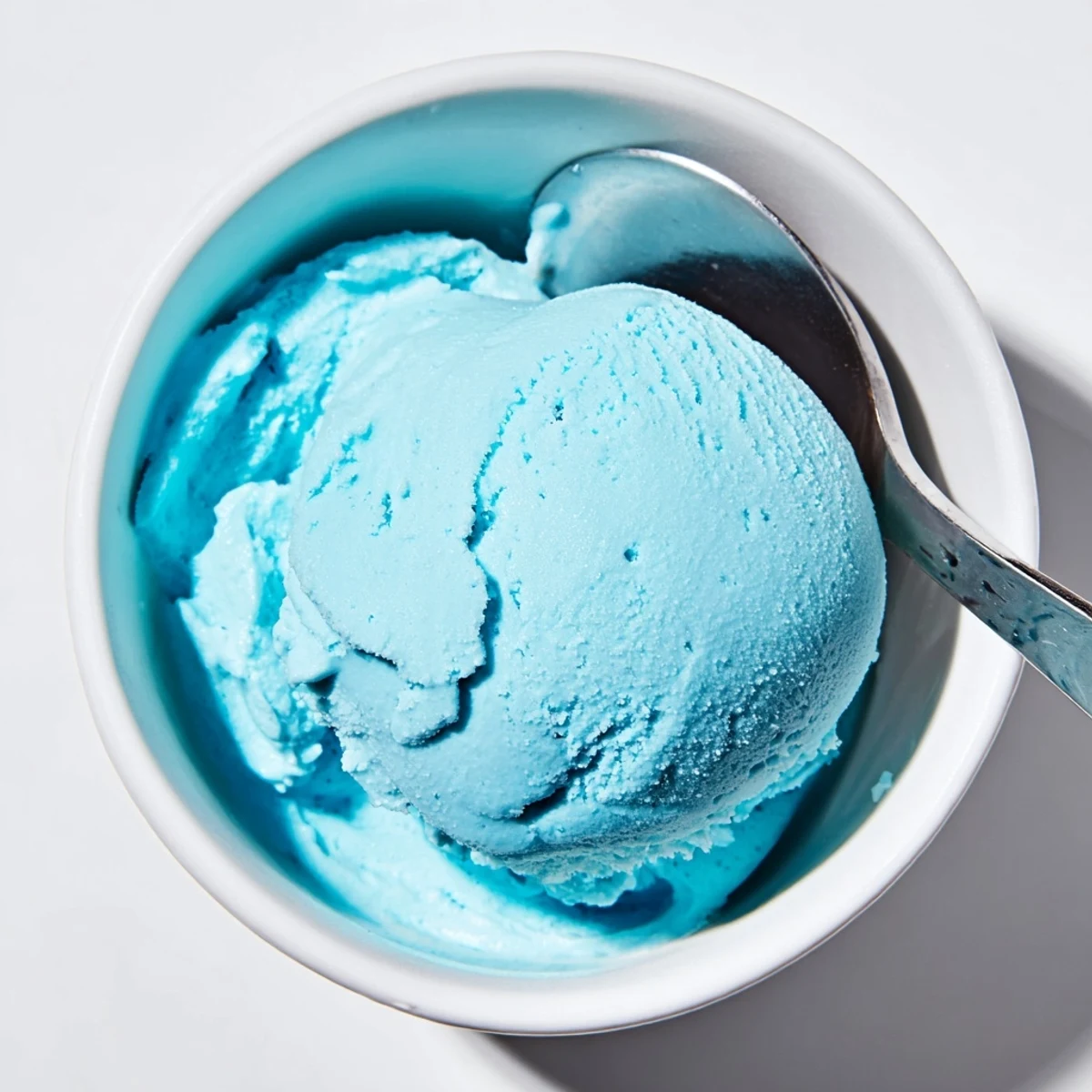 Creamy homemade Blue Moon ice cream scooped into a crispy waffle cone with colorful sprinkles