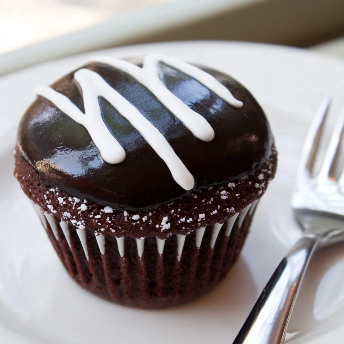 Homemade Hostess Cupcakes with glossy chocolate ganache and signature white icing swirls