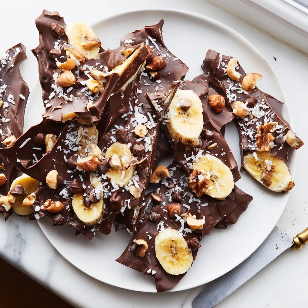 Creamy chocolate banana bark topped with roasted nuts and flaky sea salt