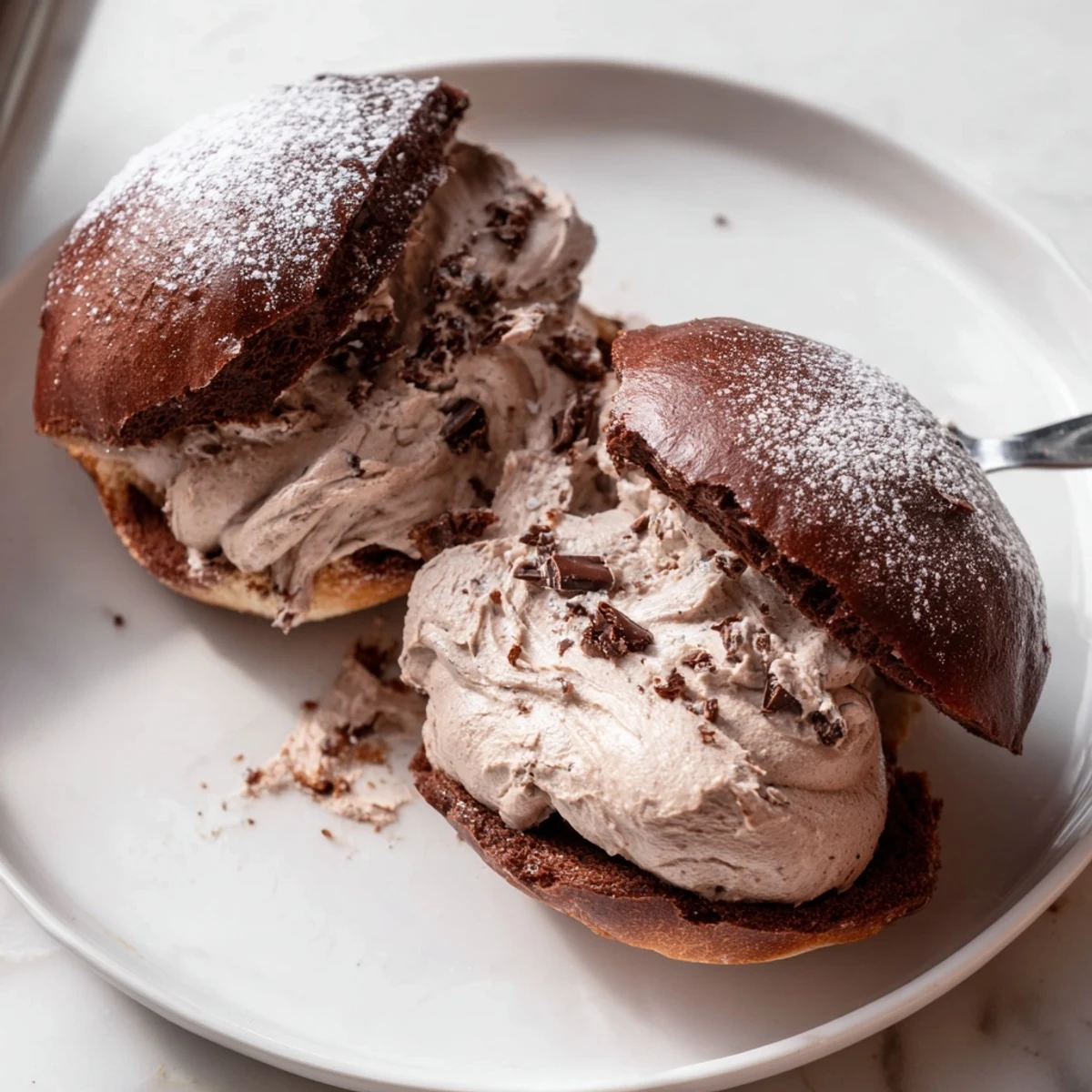 Dusted with powdered sugar, these Italian Chocolate Maritozzi showcase pillowy buns brimming with rich ganache cream