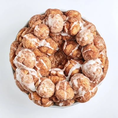 Pull-apart high protein no sugar monkey bread sprinkled with sweet cinnamon in a bundt pan