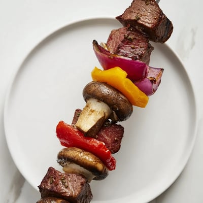 Sizzling summer steak kebabs with savory soy balsamic marinade featuring charred vegetables and tender beef cubes