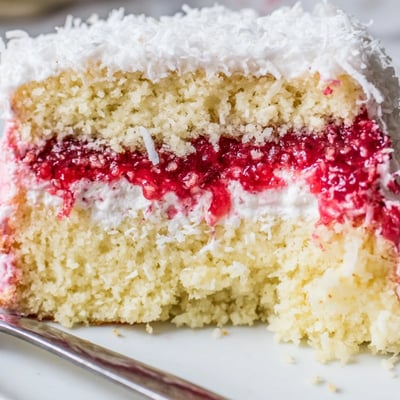Tender raspberry lamingtons with jam and cream sandwiched between sponge layers